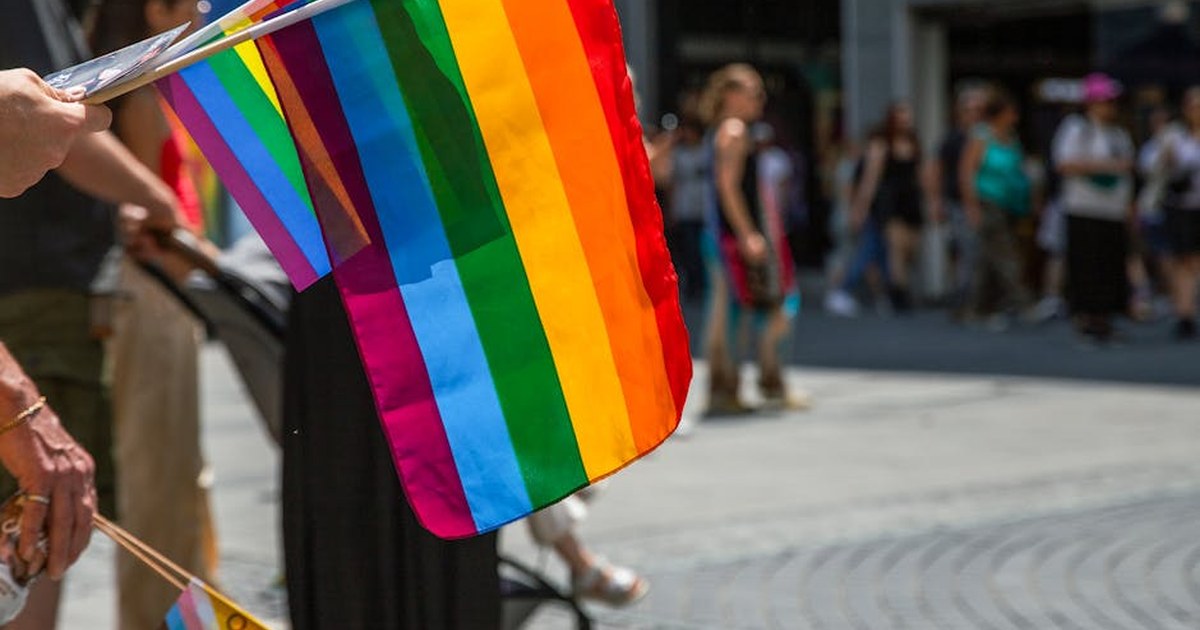 Drapeaux arc-en-ciel et Progress Pride brandis dans une rue, symbole de la stratégie européenne pour l'égalité des personnes LGBTIQ+